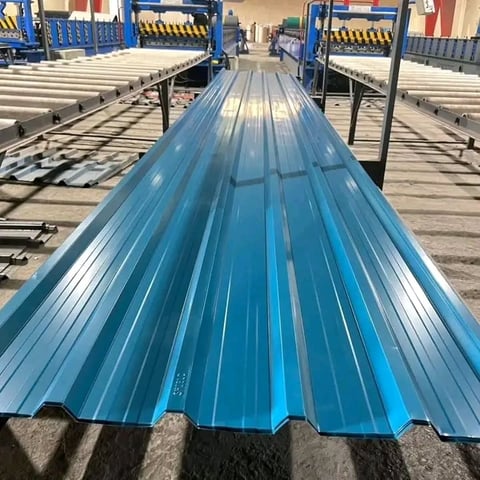 Blue corrugated metal roofing panel on industrial production line with machinery and equipment in background
