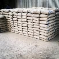 Stacked bags of cement or powder material in an industrial warehouse setting