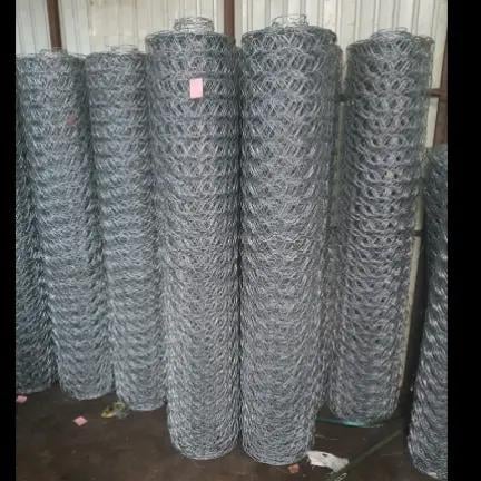 Rolls of galvanized hexagonal wire mesh fencing stacked vertically