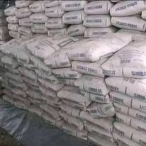 Stacked white sacks of cement or construction material in a warehouse or storage facility